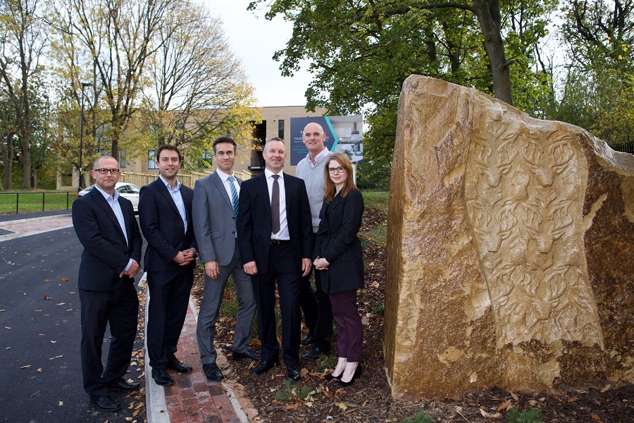 Business people next to community artwork monolith at Sheffield apartment block