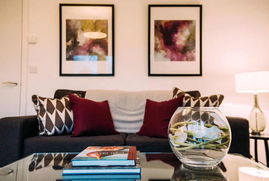 Dark sofa behind coffee table with books and vase