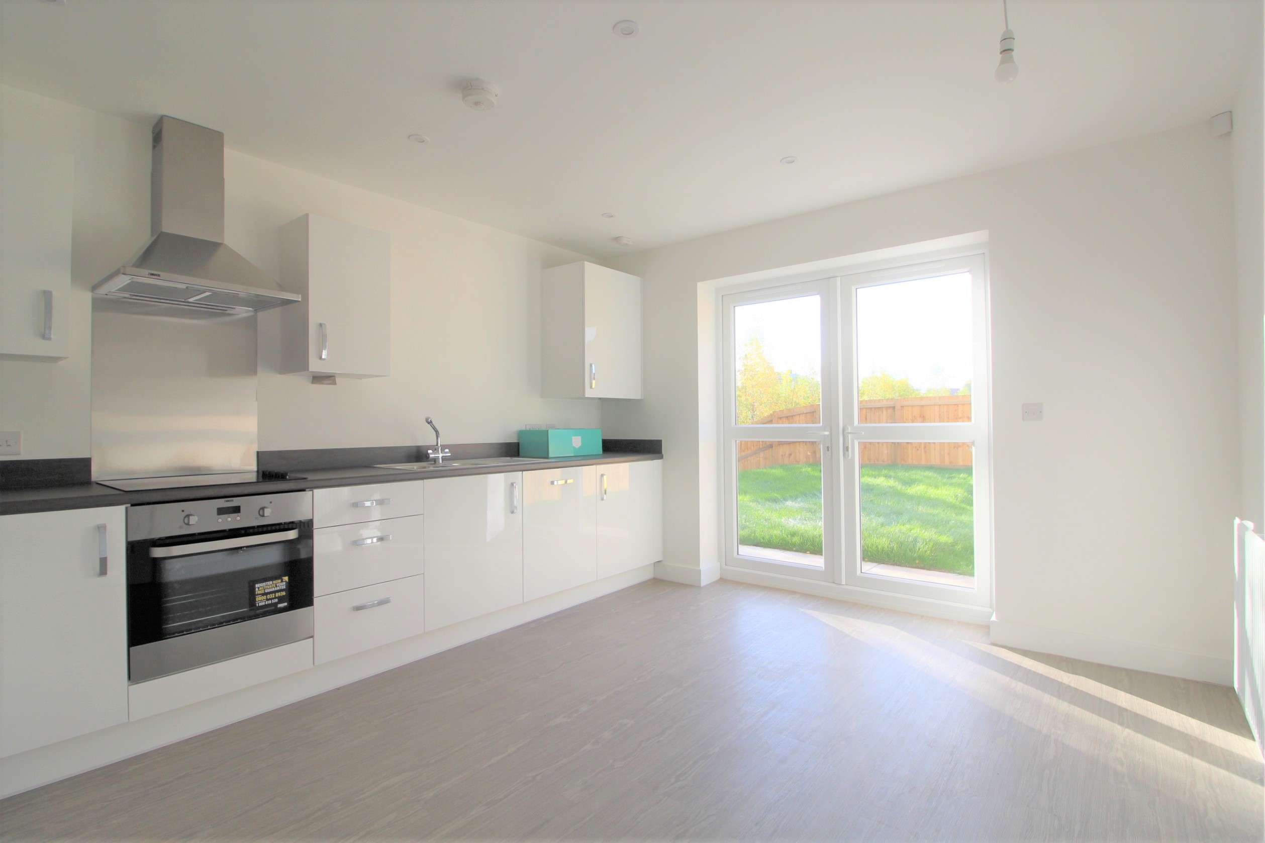 ouse white fitted kitchen and glass doors to the garden