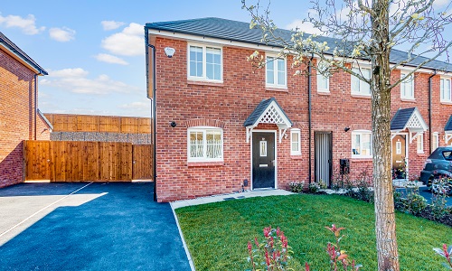 external photo of a semi-detached house with driveway and lawned garden, with tree in foreground