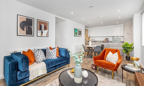 living room shot with blue sofa and orange chair