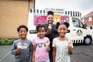 a boy, two girls and a woman smile with ice creams