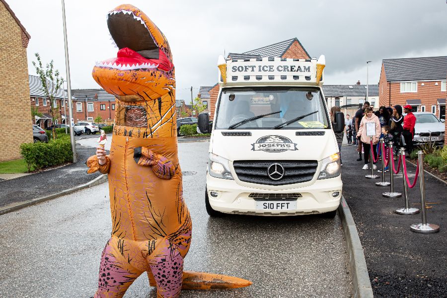 person in t-rex outfit next to an ice cream van