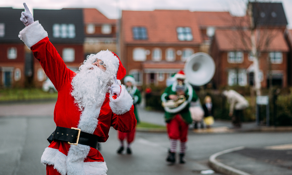 Santa Claus posing with elves in the background