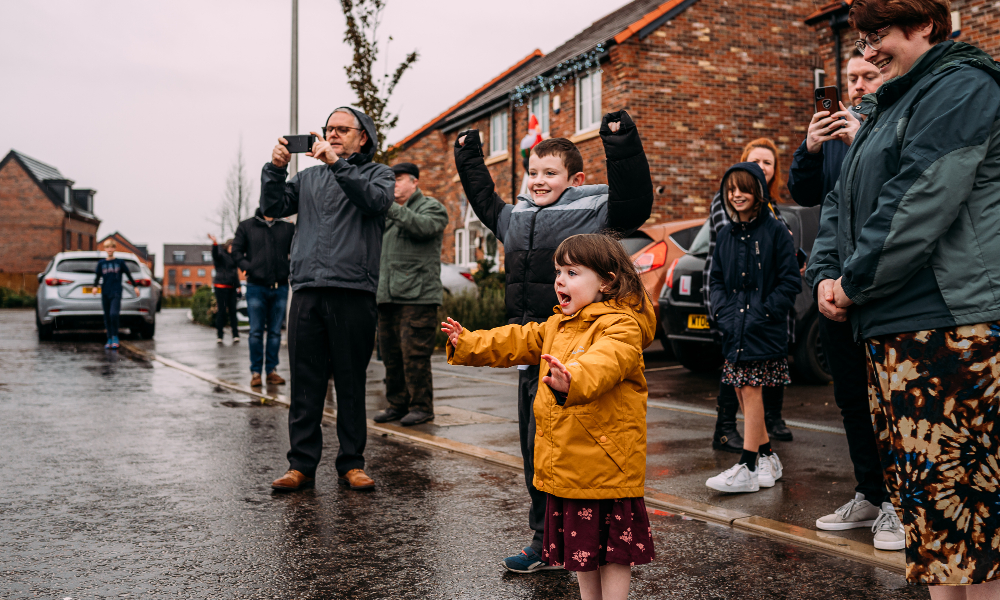 Children jump excitedly in a road