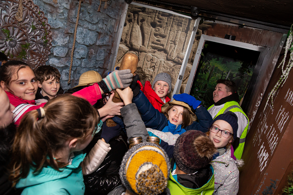 school children lift up a totem together