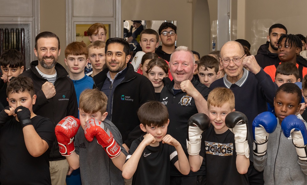 Group of children and adults pose in boxing gloves