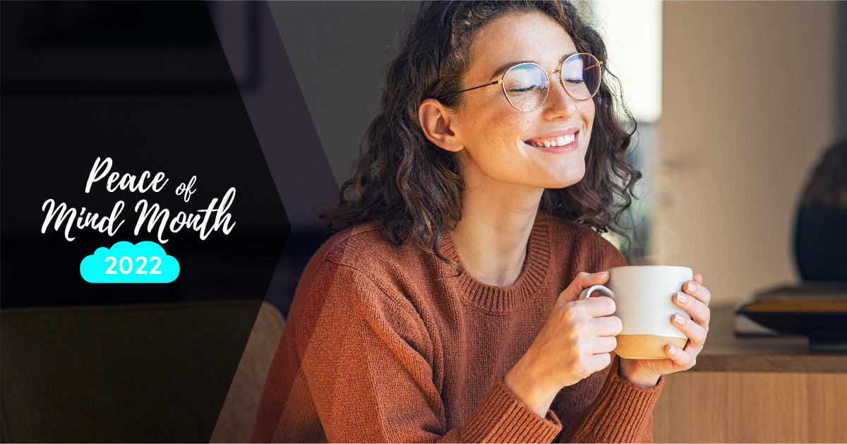 woman in glasses holds a teacup and smiles with her eyes closed