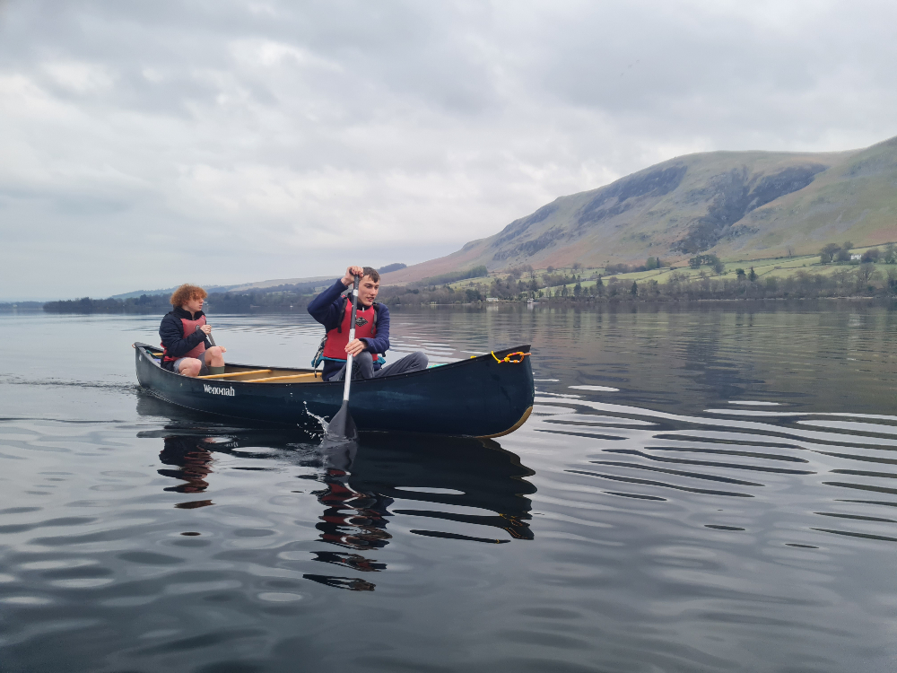 Young adults rowing in a boat