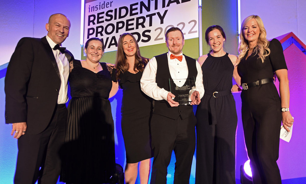 People in black tie outfits accept an award