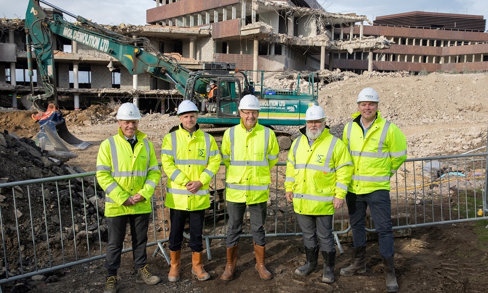 5 guys posing for picture in front of construction