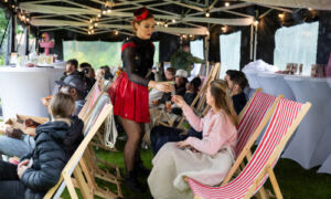 Residents on deck chairs taking drinks from the waitress