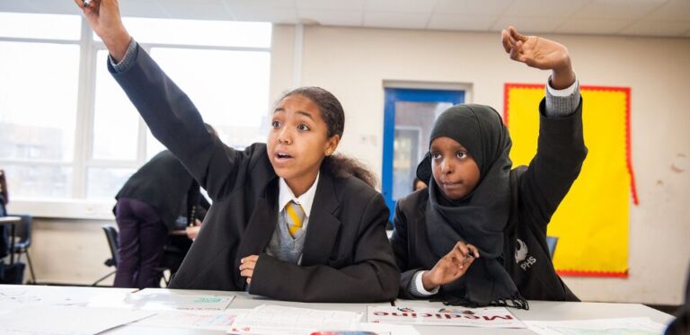 Girls in lesson putting their hands up