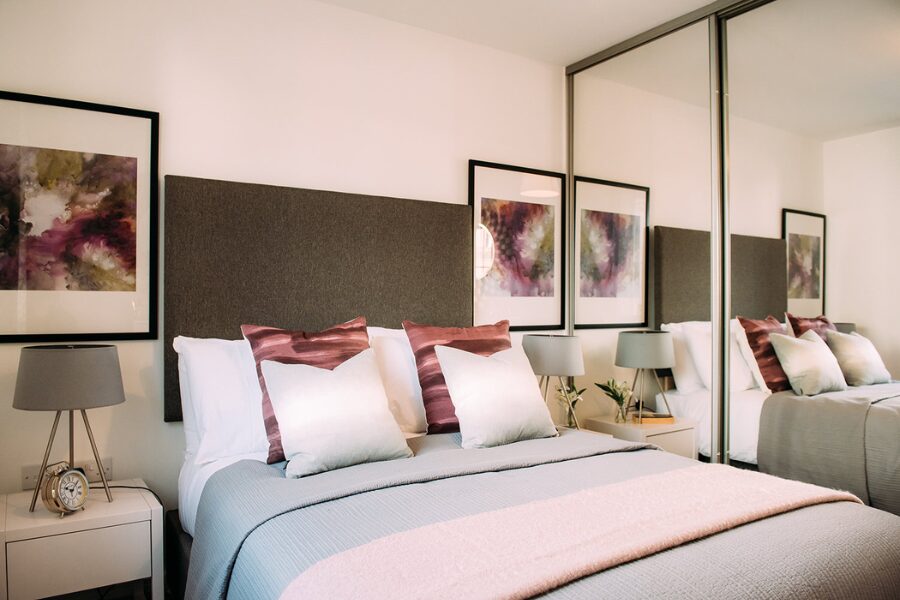 furnished bedroom with fitted mirrored wardrobe