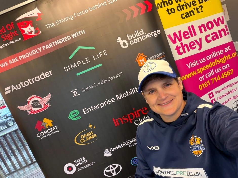 Edinburgh Giants member smiling at Speed of Sight partner wall, including Simple Life and Sigma Capital Group logos
